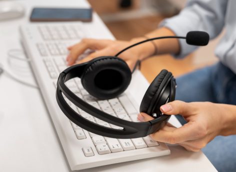 woman-working-call-center-holding-pair-headphones
